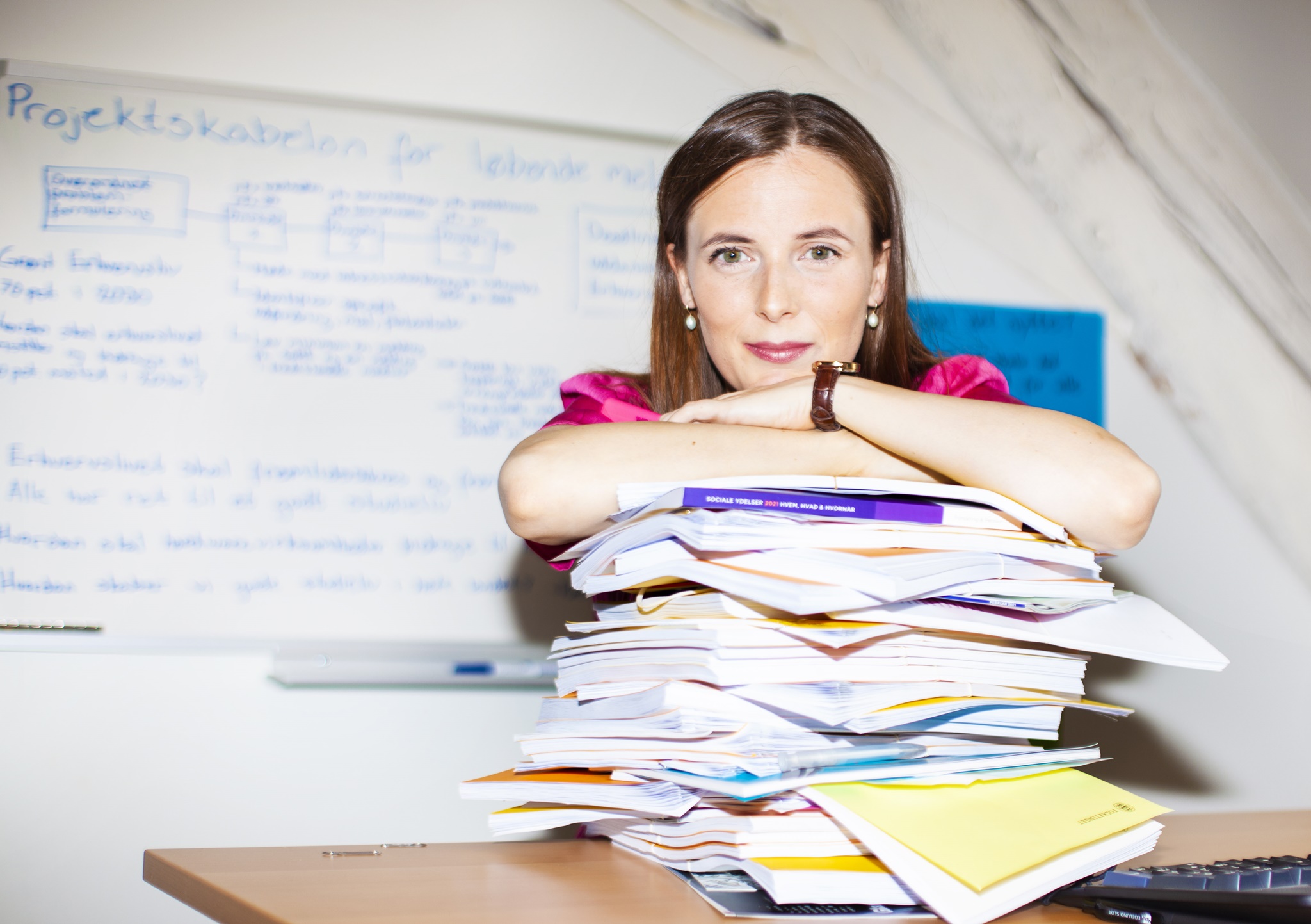 Katrine Robsøe på sit kontor med en stak bøger og rapporter
