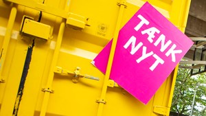 Tænk nyt-skilt foran en gul container