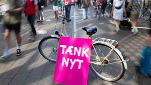 Tænk nyt-skilt sammen med en cykel på Strøget