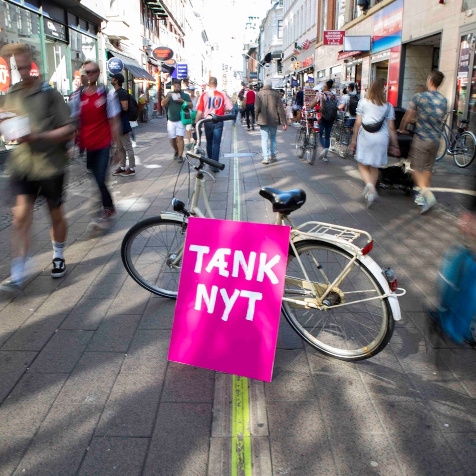Tænk nyt-skilt sammen med en cykel på Strøget
